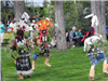 People Wearing Traditional Native American Attire Dancing for Spectators