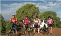 Four Bicyclists Standing by Their Bikes on a Dirt Road