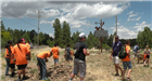 People Wearing Orange T-Shirts Gathered Working on a Project by Nature Center Sign