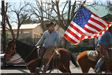 Uniformed Law Enforcement Officer on Horseback Holding U.S. Flag