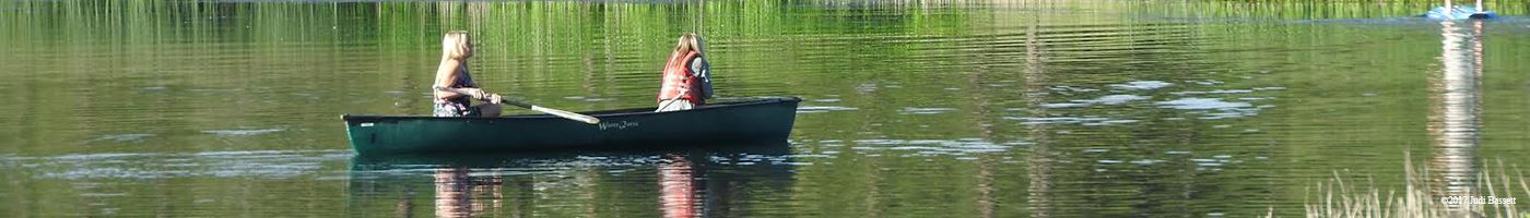Two People Paddling a Canoe on a Lake