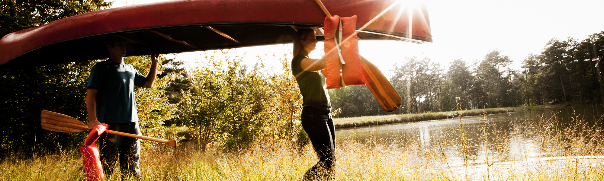 Two People Carrying a Canoe Over Their Heads