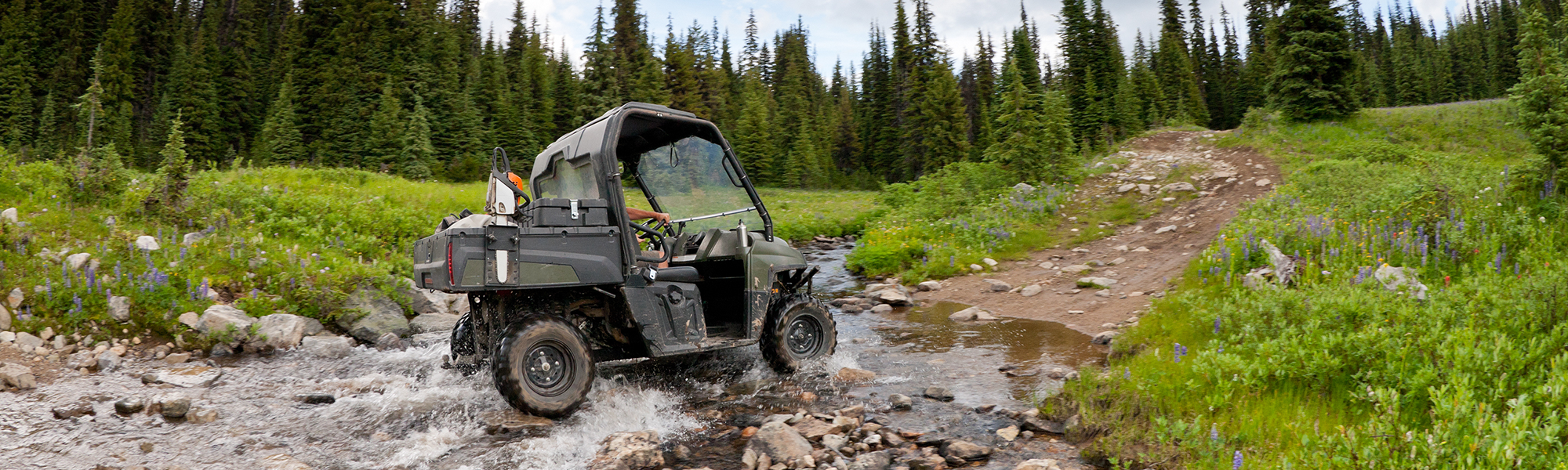 All Terrain Vehicle Riding on a Trail over a Stream