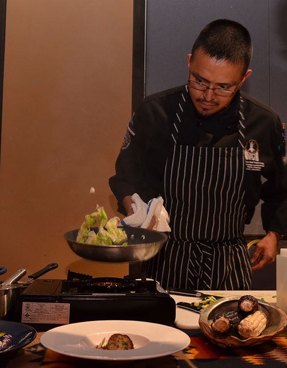 Man in Apron Cooking on a Portable Stove