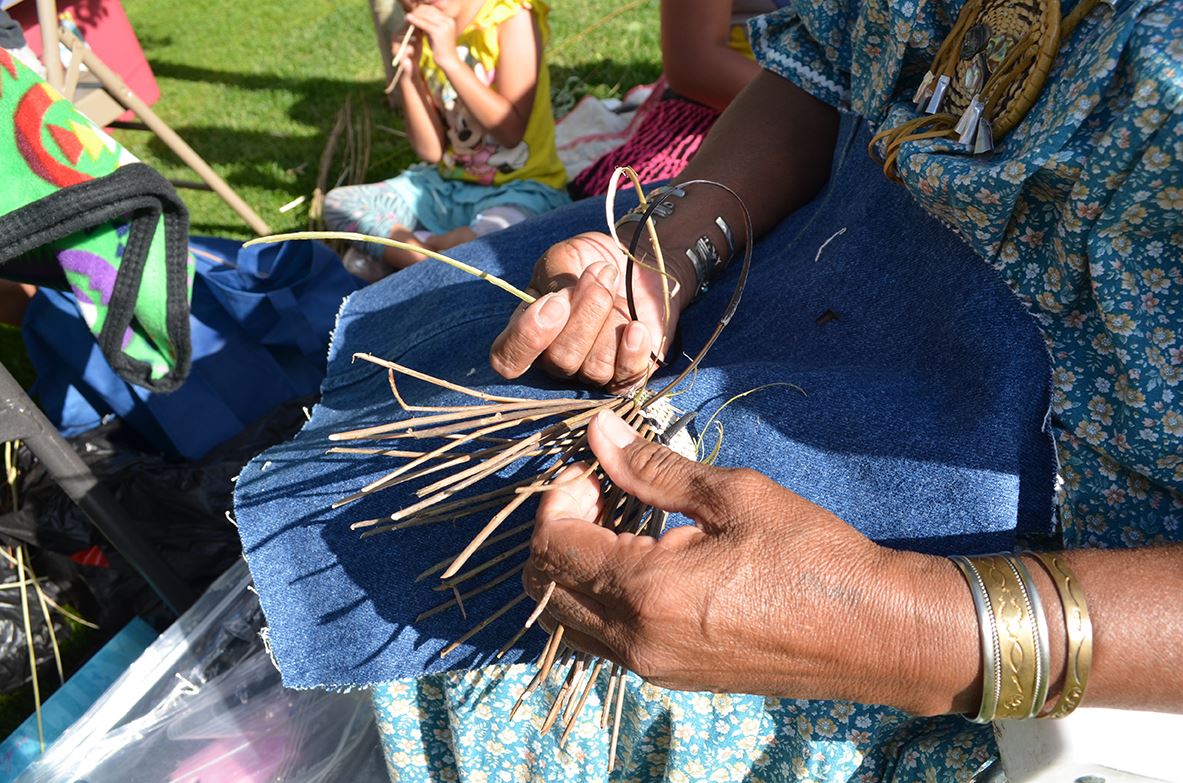 Person Wearing Bracelets Constructing an Item Using Sticks