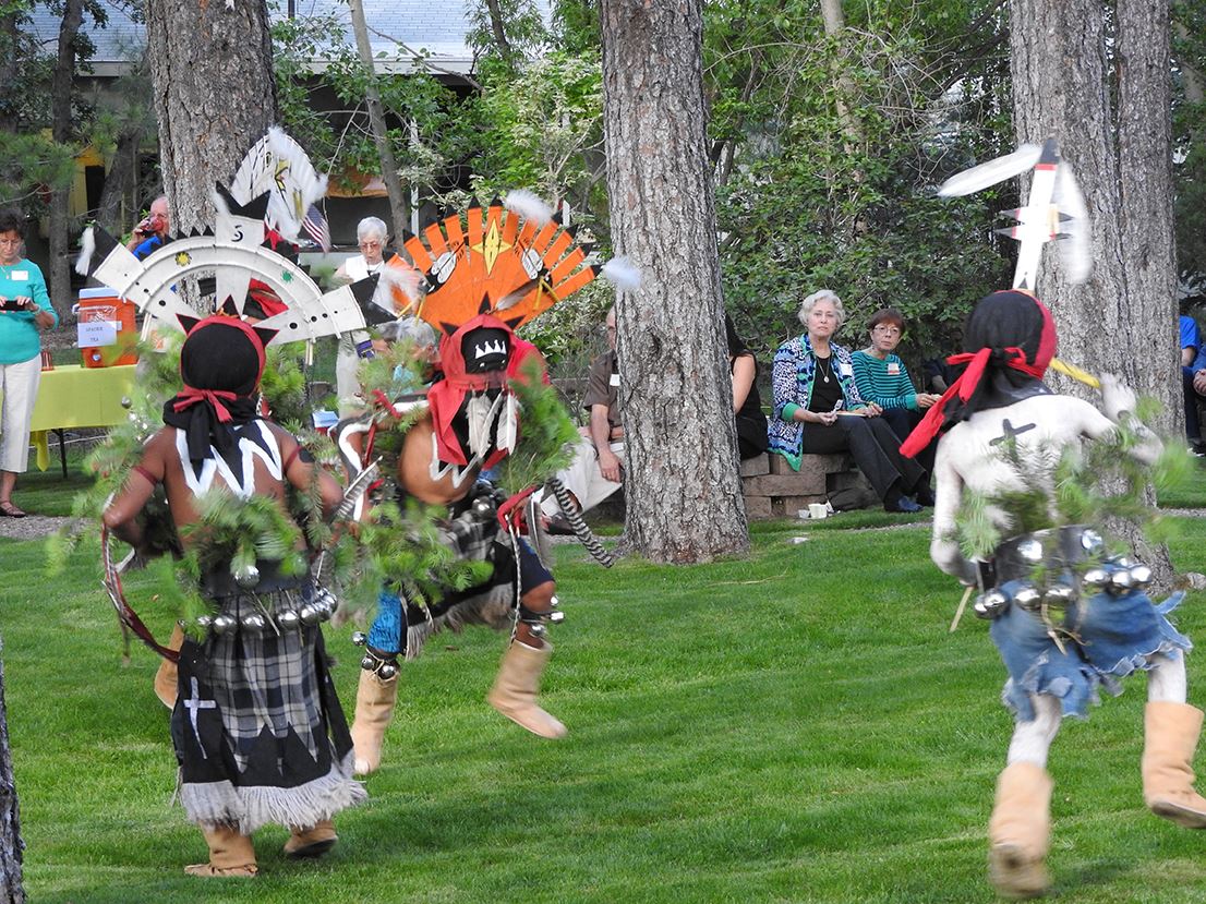 People Wearing Traditional Native American Attire Dancing for Spectators