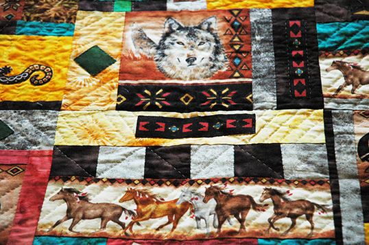 Colorful Quilt Featuring Various Designs, Wolves, and Horses