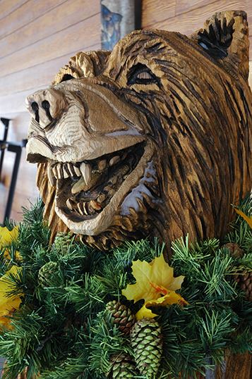 Statue of a Bear with a Holiday Wreath Around Its Neck