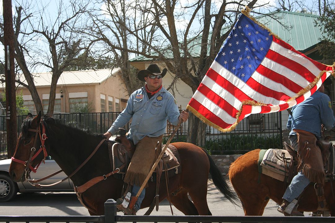 Uniformed Law Enforcement Officer on Horseback Holding U.S. Flag