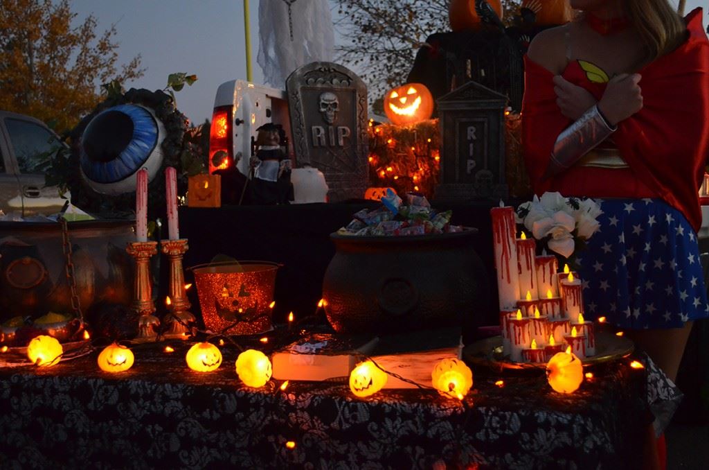 Woman in Costume Standing Next to Halloween-Decorated Table