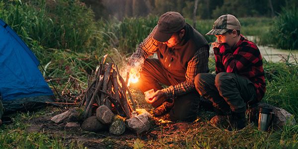 Man and Boy Building a Campfire