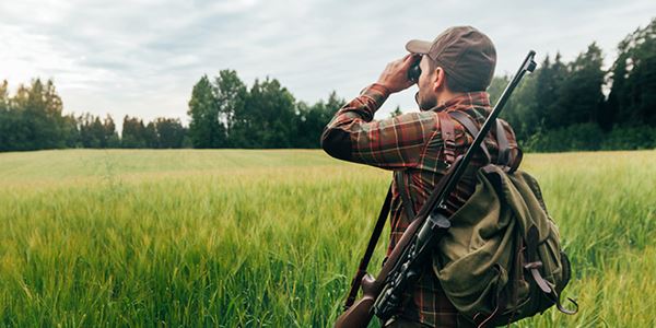 Hunter Looking Across a Field Using Binoculars