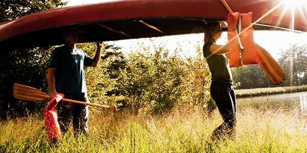 Two People Carrying a Canoe Over Their Heads